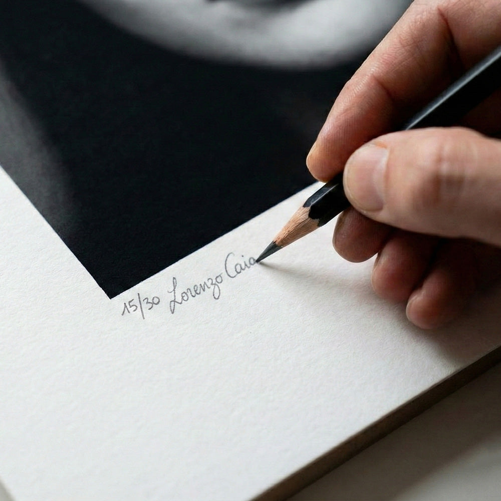 Mano dell'artista che appone firma autografa e numerazione a matita su stampa fine-art in edizione limitata 15/30