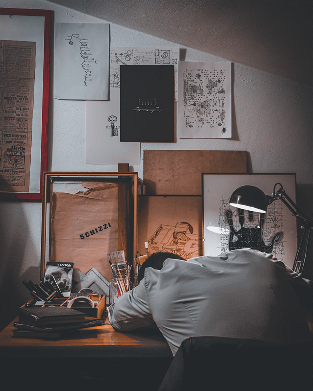 Lorenzo Caia nel suo studio di lavoro, circondato da disegni tecnici, appunti e opere d’archivio, durante il processo creativo.