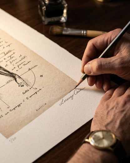 Primo piano di Lorenzo Caia che firma a matita l'edizione limitata dell'opera Brachium, a garanzia di autenticità e artigianalità.