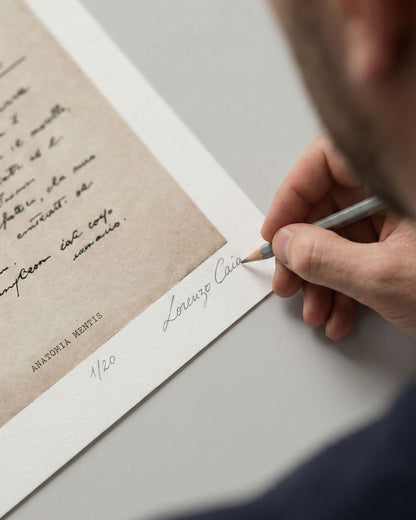 Dettaglio della mano dell'artista Lorenzo Caia mentre appone la firma autografa a matita e la numerazione 1/20 sulla stampa fine art "Anatomia Mentis". Garanzia di autenticità per collezionisti.
