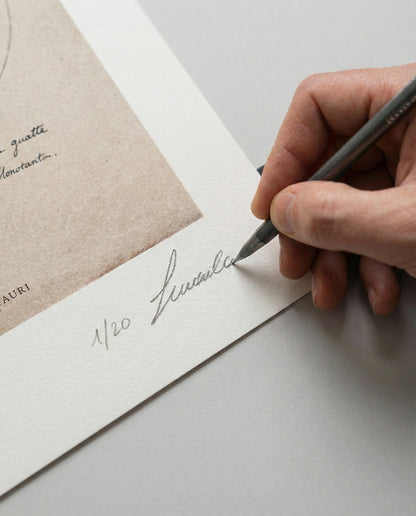 Dettaglio della mano dell'artista Lorenzo Caia mentre appone la firma autografa e la numerazione 1/20 sulla stampa fine art "Studium Minotauri". Garanzia di autenticità per collezionisti.